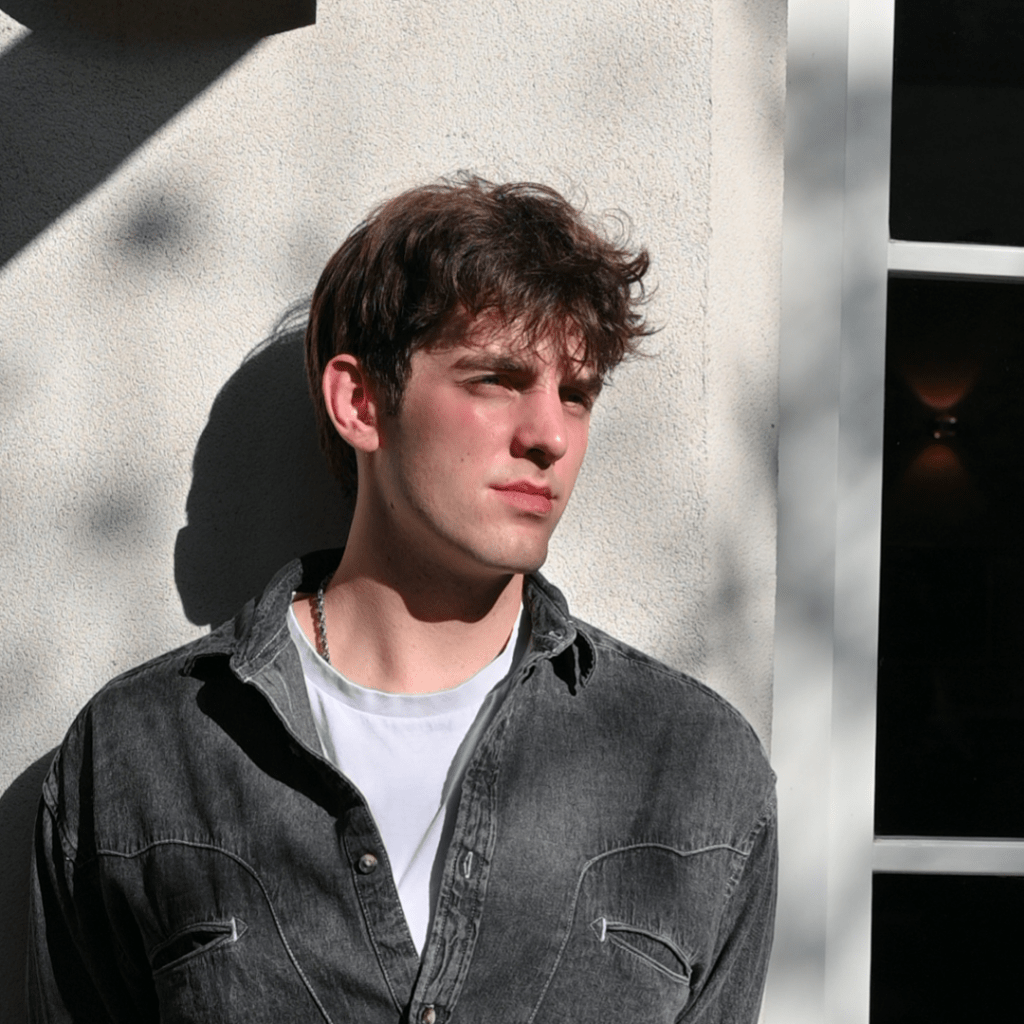 Portrait of the artist with sunlight on his face, looking slightly to the right of the camera